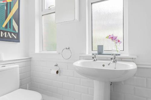 a bathroom with a sink and a toilet and a window at Kessel House - Outstanding family home, close to town centre in Dartmouth