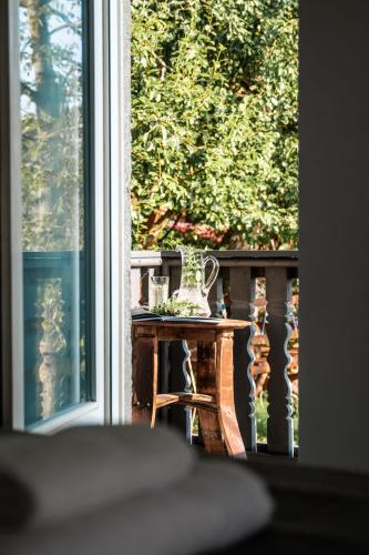 a table with a vase on a balcony with a window at Mjesto za odmor Golden Hill in Šandrovac