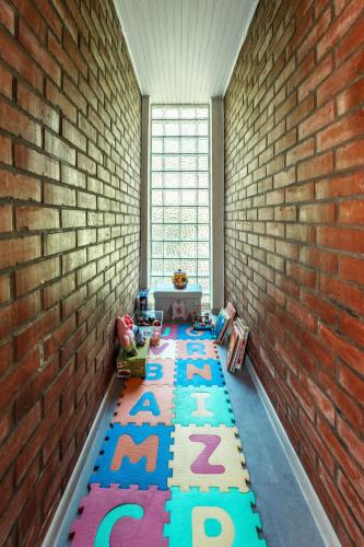 a room with a brick wall and a rug with letters at Mjesto za odmor Golden Hill in Šandrovac