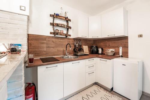 a kitchen with white cabinets and a sink at Mjesto za odmor Golden Hill in Šandrovac