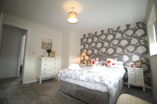 une chambre avec un grand lit et deux tables de nuit dans l'établissement 2 Bedroom House - Beautifully Decorated & Furnished - Parking - Large Garden, à Ashington