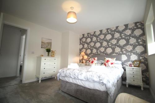 a bedroom with a large bed and two night stands at Ashington - 2 Bedroom House - Beautifully Decorated & Furnished - Large Garden in Ashington