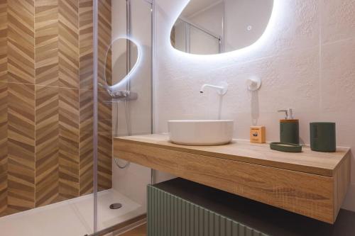 布雷斯地區布爾格的住宿－Le Balcon du 21，一间带水槽、镜子和淋浴的浴室