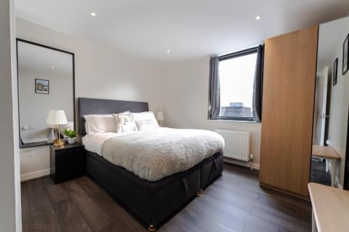 a bedroom with a bed and a large mirror at Belfast Quarters: 10th Floor Gem in Belfast