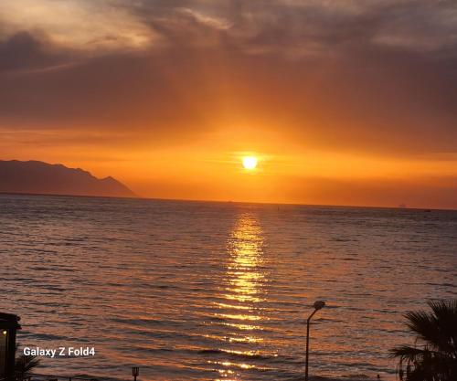 a sunset over the ocean with the sun setting at Lulubay Rooms & Suites in Kuşadası