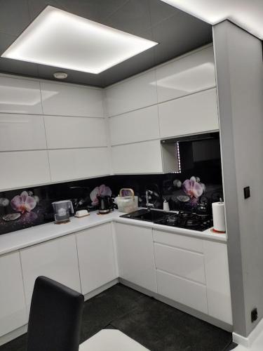 a kitchen with white cabinets and a stove top oven at Nowoczesne mieszkanie 63m2 in Jastrzębie Zdrój