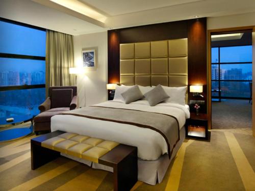 a bedroom with a large bed and a large window at Radisson Blu Chattogram Bay View in Chittagong