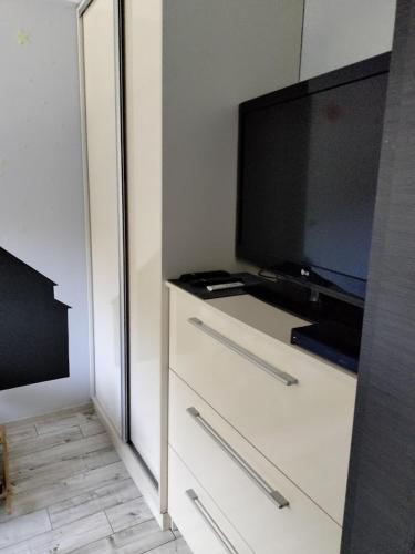 a room with a tv and a dresser with a flat screen television at Nowoczesne mieszkanie 63m2 in Jastrzębie Zdrój