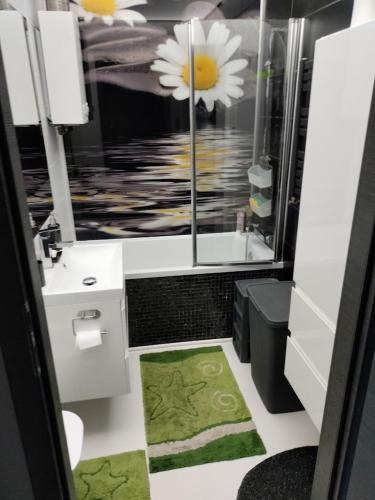 a bathroom with a sink and a window with flowers at Nowoczesne mieszkanie 63m2 in Jastrzębie Zdrój
