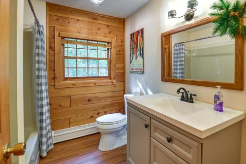 a bathroom with a toilet and a sink and a mirror at Cozy Gore Mountain Cabin with Game Room and Fire Pit in North Creek