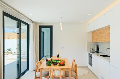 a kitchen and dining room with a wooden table and chairs at Villa Neo with Jakuzi,indoor pool,sauna and floor heating in Fethiye