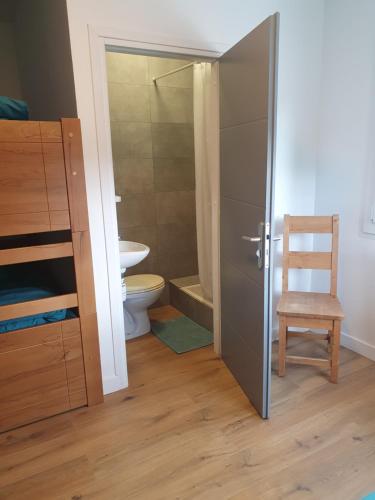 ein Badezimmer mit einer Dusche, einem WC und einem Stuhl in der Unterkunft Chalet Jaune CHAMECHAUDE in Sarcenas