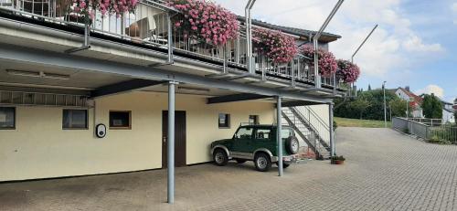 a green jeep parked next to a building with flowers at Landgasthof Zur scharfen Ecke in Hildesheim
