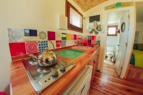 a kitchen with a stove with a tea kettle on it at Habia una vez un vagon in El Bolsón