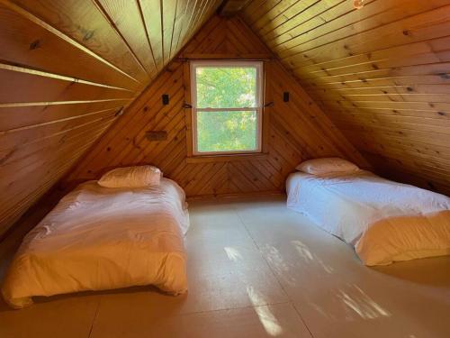 2 letti in una camera in legno con finestra di Private cabin, close to town ad Anna