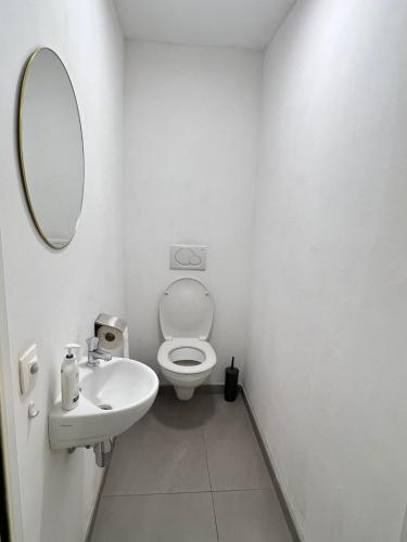 Baño blanco con aseo y lavamanos en Alexa Residence - Appartement 1, en Roeselare