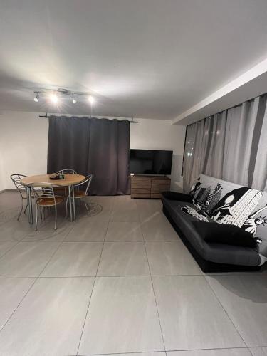 Alexa Residence - Appartement 1 في روسيلاري: غرفة معيشة مع أريكة سوداء وطاولة