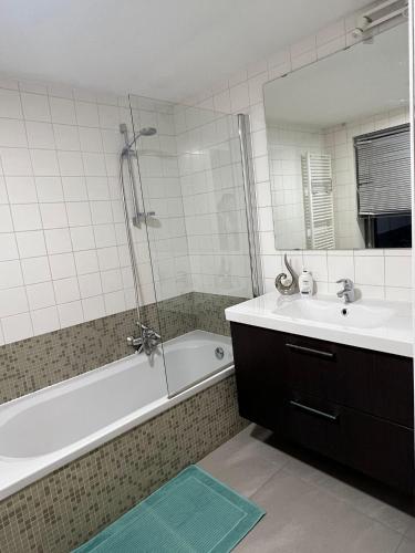 y baño con bañera, lavamanos y ducha. en Alexa Residence - Appartement 1, en Roeselare