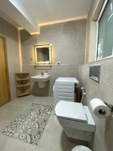 a bathroom with a toilet and a sink at Lemon Tree Residence in Amman