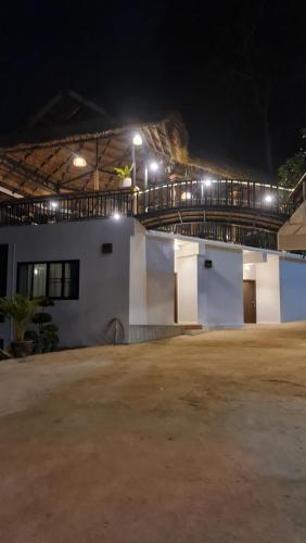 a building with a parking lot at night at สวนส่อผ่า&ฟาร์มสเตย์ in Mae Sai