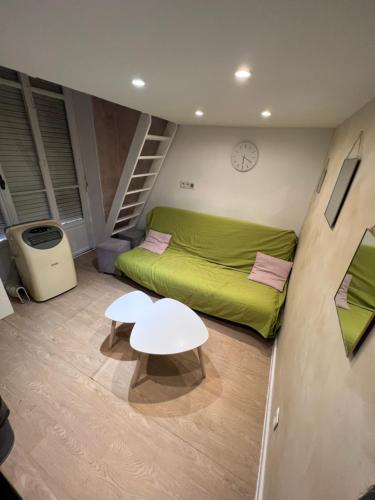 Cette petite chambre comprend un lit vert et une table. dans l'établissement Hanna, à Nice