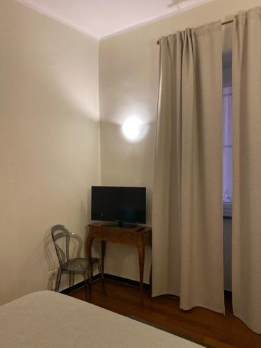 a bedroom with a bed and a desk with a television at 2SanSiro in Genova