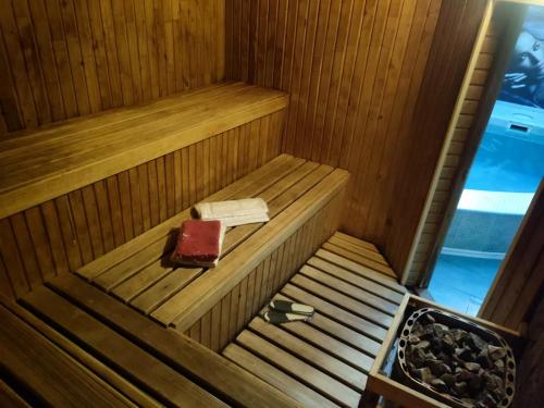 una sauna de madera con un libro y una caja. en Lisova - Лісова готельня і сауна, en Kiev