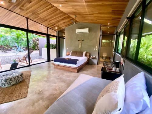 a bedroom with a bed and a large window at Villas Kalei in Playa Grande