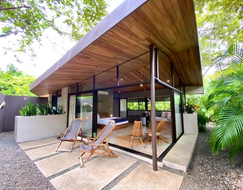 a house with glass walls and a patio at Villas Kalei in Playa Grande