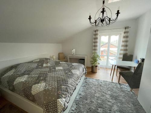 1 dormitorio con cama y lámpara de araña en Ferienwohnung "do is schee", en Blaibach
