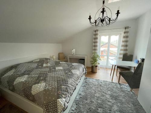 a bedroom with a bed and a chandelier at Ferienwohnung und Zimmer "do is schee" in Blaibach