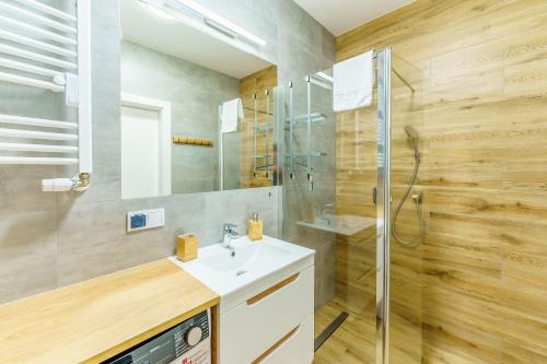 a bathroom with a sink and a shower at Apartament z Widokiem na Morze - Błękitna Perła by Perłowa Przystań Rent in Sianozety