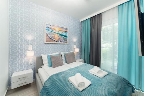 a bedroom with a bed with two towels on it at Apartament z Widokiem na Morze - Błękitna Perła by Perłowa Przystań Rent in Sianozety