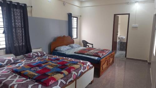 a bedroom with two beds in a room with a window at YETTI-A GUEST HOUSE in Yercaud