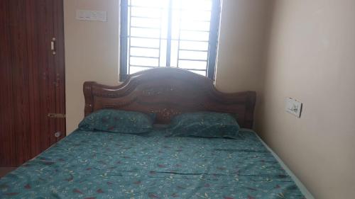 a bed with two pillows in a bedroom with a window at YETTI-A GUEST HOUSE in Yercaud