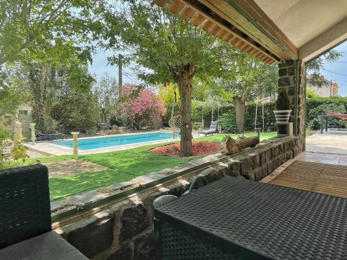 une terrasse avec un mur en pierre et une piscine dans l'établissement Villa au calme avec piscine et sauna, à Cazouls-lès-Béziers
