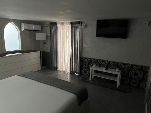 a bedroom with a bed and a tv on the wall at A un passo dal Castello Maschio ANGIOINO Appartment in Naples