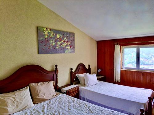 una camera d'albergo con due letti e una finestra di Mélita Guesthouse a Braga