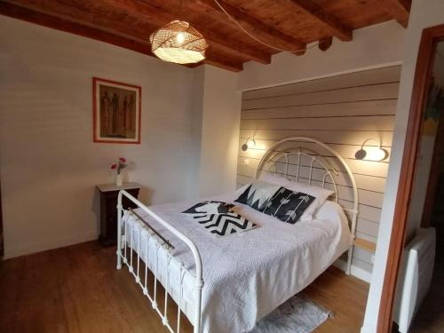 a bedroom with a white bed and a wooden ceiling at La Tignoise in Tignac