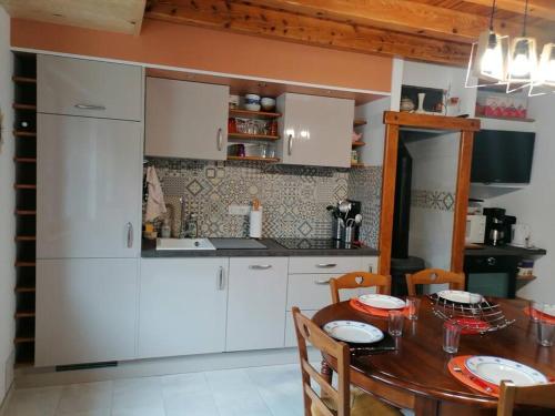 a kitchen with white cabinets and a wooden table at La Tignoise in Tignac