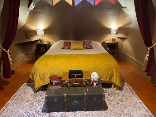 a bedroom with a bed with a yellow bedspread at Le gîte du Sorcier 89 in Avallon