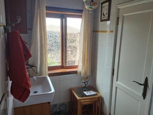 a small bathroom with a sink and a window at Casa Heidica, a pies del Tajogaite in Los Llanos de Aridane