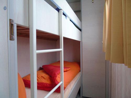 a bunk bed with an orange pillow on the bottom bunk at Ferienwohnung Rose in Loissin