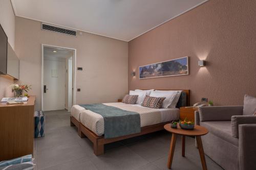 a hotel room with a bed and a couch at Skiathos Palace Hotel in Koukounaries