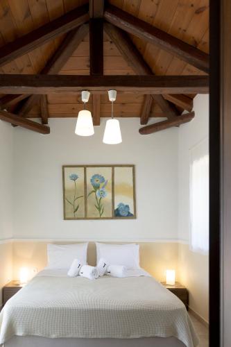 a bedroom with a bed with two white towels at Trochalo Villas 2 in Stoupa