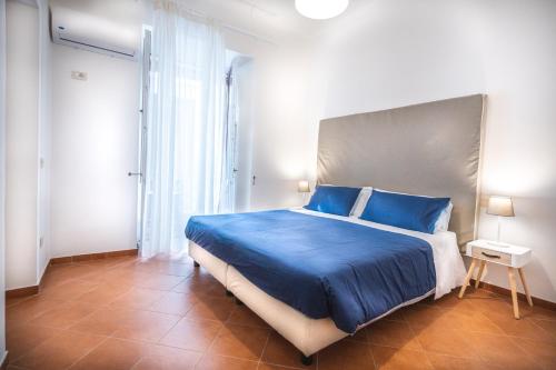 a bedroom with a large blue bed with blue pillows at Room Giuliani in Sorrento
