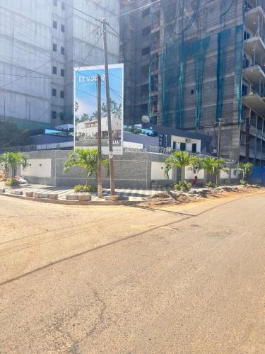 una calle vacía en una ciudad con un gran cartel en Paryssonalo en Dakar