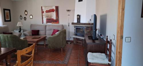 sala de estar con sofá, mesa y TV en Casa Obdulia, en Vilvestre