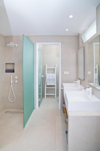 a bathroom with two sinks and a walk in shower at Almyra Seaside Luxury Suites in Kalymnos
