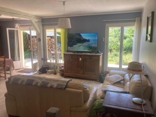 ein Wohnzimmer mit einem Sofa und einem Flachbild-TV in der Unterkunft Chez Christine et Claude in Neufmontiers-lès-Meaux